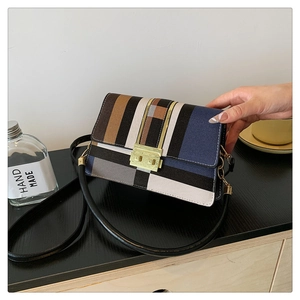 Detail of color-block striped shoulder bag with gold metal buckle and leather strap