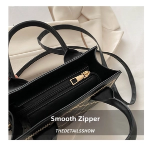Detailed close-up of smooth gold-tone zipper and quilted black leather on handbag