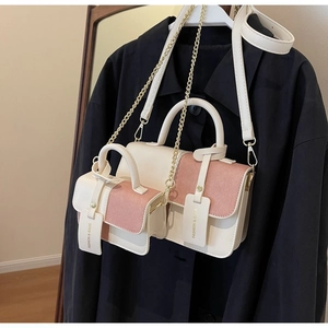 Fashionable beige and pink patchwork crossbody bag set with gold chain strap on coat
