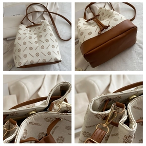 Detail view of printed bucket bag showing golden magnetic closure and canvas leather texture