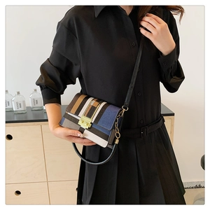 Close-up of color-block striped crossbody bag with gold clasp and black handle