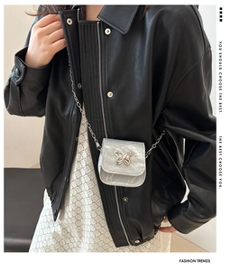 Close-up of textured silver mini crossbody bag with butterfly buckle and chain strap