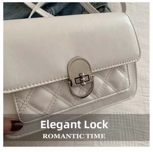 Detailopname van een witte gewatteerde crossbodytas met een verfijnd metalen slotje