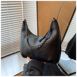 Détail du sac demi-lune en cuir grainé noir avec surpiqûres et chaîne argentée
