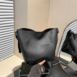 Minimalist black lychee texture leather bucket bag with wide strap and side buckle