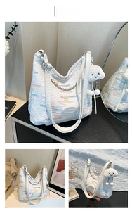 Detail of white quilted tote bag featuring colorful wavy embroidery and plush cloud charm