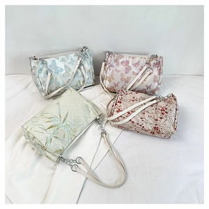 Detailed close-up of four floral silk shoulder bags with chain straps in varied patterns