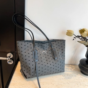 Chic grey tote bag with black bow print and metallic silver bow accent for daily use