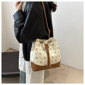 Detail of cream bucket bag with vintage print, drawstring closure and thin strap