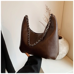 Détail du sac cabas marron foncé avec coutures en croix et bandoulière chaîne