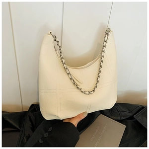 Vue détaillée du sac hobo crème avec texture matelassée et bandoulière chaîne argent