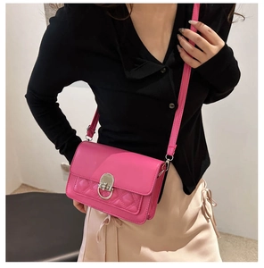 Detail van roze crossbodytas met gewatteerde textuur en zilveren draaisluiting