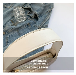 Detailed close-up of cream leather shoulder strap with fine stitching on floral lace bag