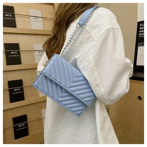 Sac bandoulière bleu clair matelassé avec surpiqûres en V et chaîne métallique chic