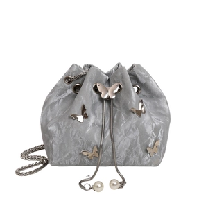 Silver drawstring bucket bag with metallic butterfly accents and pearl detail straps