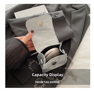 Detailed view of silver mini chain bag showing interior capacity for a cushion compact