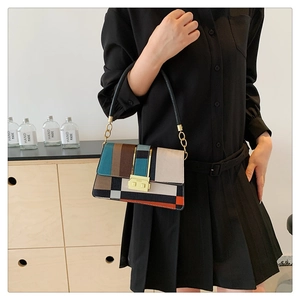 Close-up of geometric patchwork leather crossbody bag with chic gold metal clasp detail