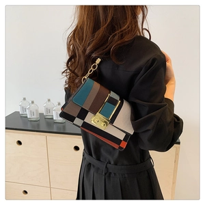 Detail shot of multi-color patchwork shoulder bag with gold clasp on a model