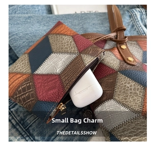 Dettaglio mini borsa ciondolo in pelle geometrica con zip in metallo e cinturino