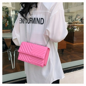 Détail du petit sac carré rose matelassé en V avec bandoulière chaîne argentée