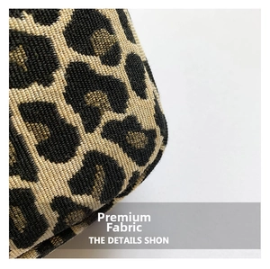 Detailed close-up showing the leopard print pattern on woven fabric shoulder bag