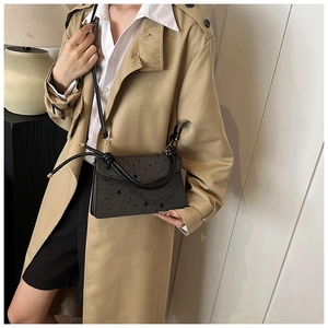 Schicke dunkelgraue Umhängetasche mit Sternenprint und Knotengriff an Model in Trenchcoat