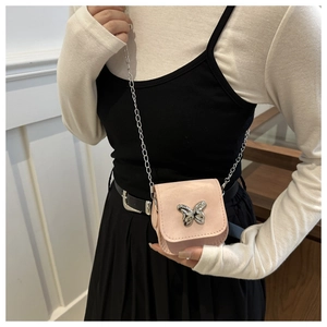 Detailed view of pink mini crossbody bag with a large silver butterfly metal buckle and chain