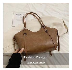 Détail de la texture en cuir marron mat du sac cabas et de sa boucle latérale chic