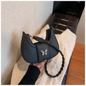 Détail du sac croissant noir avec fermoir papillon argenté et poignée tressée