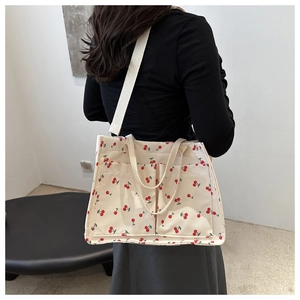 Detail of canvas tote bag with cherry print featuring two practical front open pockets