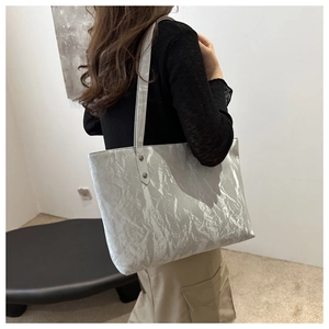 Détail d'un cabas argenté métallisé avec texture plissée et longues bandoulières