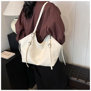 Détail du grand sac cabas en similicuir crème avec boucle argentée et bandoulière