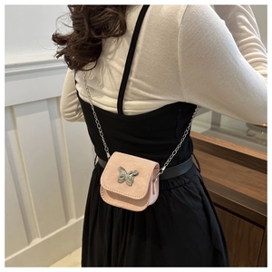 Back view of model wearing a pink mini crossbody bag with a metal butterfly clasp