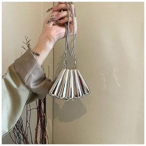 Detail of a silver shell-shaped evening bag with a metallic finish and snake chain strap