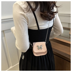Detail of pink mini saddle bag with silver butterfly buckle and delicate chain strap