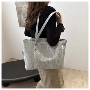 Détail du sac cabas plissé argenté avec texture métallique brillante et doubles bretelles