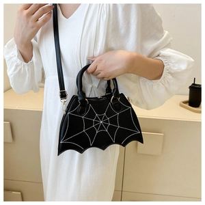 Detail of black spider web saddle bag with bat wings shape and gold hardware