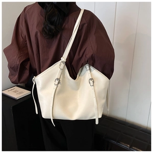 Détail du sac cabas en similicuir blanc avec fines bandoulières et boucle argentée