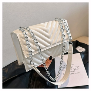 Gros plan du sac bandoulière en cuir blanc avec chaîne argentée et motif à chevrons