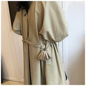 Chic gold shell-shaped mini crossbody bag with a delicate metal chain strap on a model