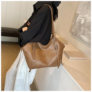 Vue détaillée d'un grand sac cabas marron en cuir PU avec des lanières à boucle chic