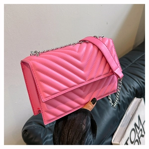 Détail du sac bandoulière rose bonbon avec surpiqûres en V et chaîne argentée