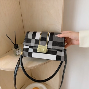 Stylish black and white checkered crossbody bag with gold buckle and top handle