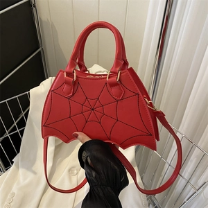 Quirky red bat-shaped crossbody bag with black spider web stitching and gold hardware