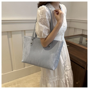 Vue détaillée du sac cabas bleu argenté avec texture plissée et anses renforcées