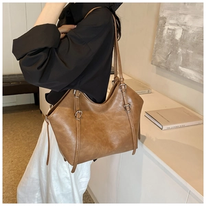 Détail d'un sac cabas marron vintage avec plusieurs sangles et boucles en métal argenté