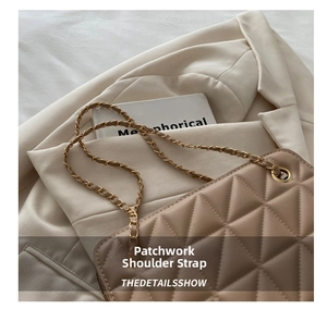 Detail view of beige quilted tote bag with metal chain strap and luxury stitching