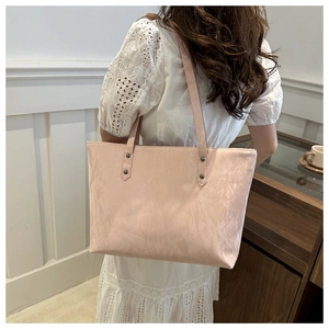 Détail du sac cabas plissé rose avec rivets métalliques foncés et fines bandoulières