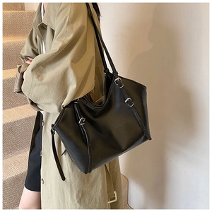 Détail du sac cabas en similicuir noir avec boucle argentée et sangles latérales