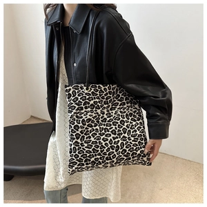 Detail of leopard print tote bag with black handles and golden eyelets for women